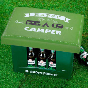Auf einem Bierkasten ist ein Bierkastensitz für Camper. Auf dem Sitz steht Happy Camper. So macht man Campinfreunde glücklich.