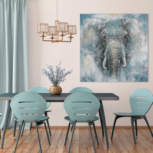 In einem Esszimmer hängt ein Gemälde welches vorwiegend die Farbe Blau hat. Auf dem Gemälde ist ein Elefantenkopf zu sehen der aus dem Nebel kommt.