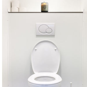 Auf einer Gästetoilette steht eine Duftkerze. Sie trägt den Spruch: Anzünden nach dem kacken.