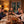 An einem gedeckten Tisch stößt eine Familie mit Gläsern und dem Scheibel Apricot Brandy an. Die Umgebung ist ein Wohnzimmer mit gemütlicher Beleuchtung. Die Familie lacht.