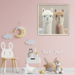 In einem Kinderzimmer hängt an der Wand ein quadratisches Bild mit Holzrahmen. Auf dem Bild sieht man zwei Lamas oder Alpakas mit Kunstfell. Das Bild heiß Best Lama Buddies.
