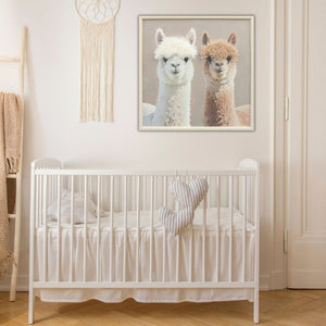 In einem Kinderzimmer über einem Kinderbett hängt ein Traumfänger und ein Bild von zwei Lamas. Beide Lamas oder Alpakas schauen in den raum und haben Frisuren aus Kunstfell.