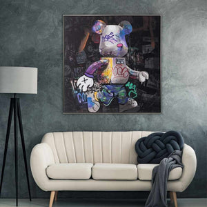 Über einer weißen Couch hängt ein Pop Art Gemälde mit schwarzem Hintergrund. Im Vordergrund ist ein Bär im Comic Style mit vielen Schriften und Graffity Elementen umgeben.