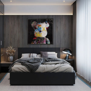 Ein modernes Schlafzimmer. Über dem Bett hängt ein düsteres und markantes Bild von einem Teddybären auf schwarzem Hintergrund. Als Auge hat er nur ein großes X. Irgendwie schein der Teddy auf dem Bild mystisch oder ein wenig angsterregend zu sein.