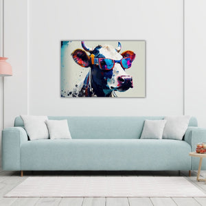 Über einem türkisen Sofa hängt an der weißen Wand ein Bild. Auf dem Kunstdruck sieht man eine bunte Kuh mit Sonnenbrille im Pop Art Style