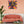 Laden Sie das Bild in den Galerie-Viewer, Über einem lachsfarbenen Sofa hängt ein buntes Acrylgemälde von einem Dackel der auch den Namen Teckel oder Dachshund trägt.
