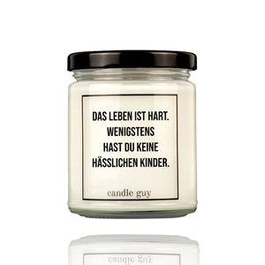 Auf einer Duftkerze steht der Spruch: Das Leben ist hart. Wenigstens hast Du keine hässlichen Kinder. Originelle Geschenkidee für den Vater oder die Mutter