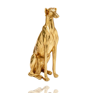 Eine goldfarbene sitzende Windhund-Skulptur der Marke KARE. Die Skulptur zeigt einen majestätischen Windhund, der ruhend und gelassen sitzt. Sein glänzendes goldfarbenes Finish verleiht ihm einen Hauch von Eleganz und Glamour. Die Skulptur strahlt Anmut und Schönheit aus und eignet sich perfekt als dekoratives Element für jeden Raum.
