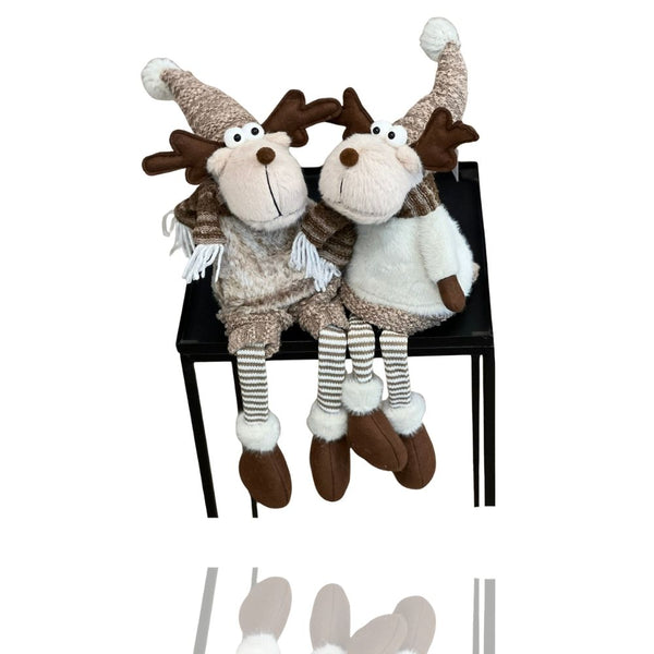 Das Kantenhocker-Paar Sven und Svenja sitzen in Winterkleidung gemütlich auf einem kleinen Tisch und lassen die Beine baumeln.