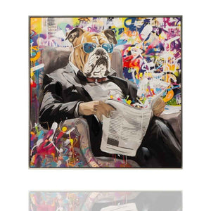 Auf einem gerahmten Acrylgemälde sieht man eine Englische Bulldogge die in einem Sessel eine Zeitung ließt.