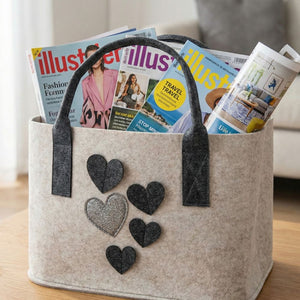 In einer beigen Filztasche stecken unterschiedliche Illustrierte. Dieses Filztasche ist eine gute Möglichkeit, Zeitungen oder Illustrierte zu verwahren.