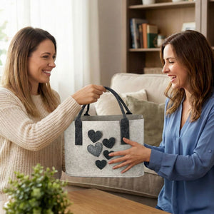 Zwei Freundinnen bewundern eine Filztasche oder Filzshopper. Auf der Filztasche sind Herzen aufgenäht