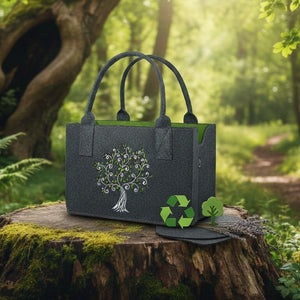 Ein dunkelgrauer Filztaschen Shopper mit einem eingestickten Lebensbaum-Motiv steht auf einem moosbewachsenen Baumstumpf in einem sonnigen Wald. Neben der Tasche befinden sich grüne Nachhaltigkeits-Icons, wie ein Recycling-Symbol und ein kleiner stilisierter Baum, um den ökologischen Charakter des Naturprodukts zu unterstreichen.