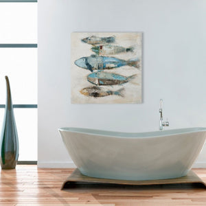 Über der Badewanne im Badezimmer hängt ein Gemälde mit blauen und türkisen Fischen. Das Gemälde strahlt Ruhe im Badezimmer aus.