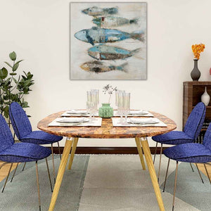 In einem Esszimmer mit blauen Stühlen hängt an der wand ein Acrylgemälde mit einem türkisen und blauen Fischchwarm