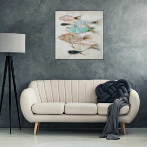 Ein Gemälde von einem Fischschwarm hängt an einer grauen Wand im Wohnzimmer. Die Fische sind in den Farben türkis, braun und rot.