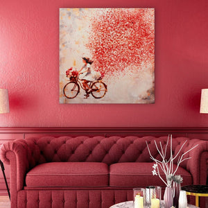 Ein rotes Sofa, eine rote Wand und ein Gemälde mit viele roten Elementen. Auf dem Gemälde fährt ein Mädchen mit dem Fahrrad und hinter dem Mädchen ist eine große Wolke aus roten und weißen Blumen.