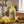 Eine gelbe Flasche mit FRANZI Zitronenrollen Likör steht auf einem Holztisch. Links daneben steht Sahne mit Zitronen. Rechts daneben liegt ein Franzbrötchen auf dem Holztisch.