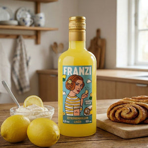 Eine gelbe Flasche mit FRANZI Zitronenrollen Likör steht auf einem Holztisch. Links daneben steht Sahne mit Zitronen. Rechts daneben liegt ein Franzbrötchen auf dem Holztisch.