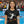 Eine junge Dame ist Handballfan und steht kurz vor dem Anpfiff mit ihrem Schwarz, Rot, Goldenem T-Shirt 
n der Handballarena. Auf dem Shirt ist eine Handballspielerin beim Torwurf zu sehen und es steht Girl Power auf dem Handball Fan T-Shirt.