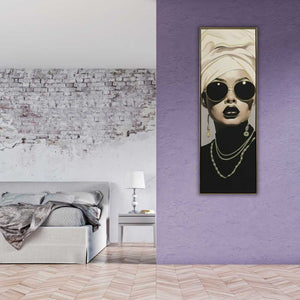 An einer lilifarbenen Wand hängt ein schwarz wei Frauenporträt einer arabischen Frau. Sie lebt im luxus Lifestyle.