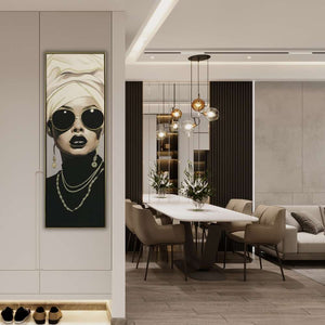 Im Flur neben dem Wohnzimmer hängt ein schmales gerahmtes Bild mit einem Frauenporträt. Die Dame lebt im Luxus Lifestyle.