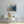 Laden Sie das Bild in den Galerie-Viewer, An der wand hängt ein Gemälde von einem blauen französischen Cafe. Ein Schreibtisch mit Stuhl steht vor dem Gemälde.
