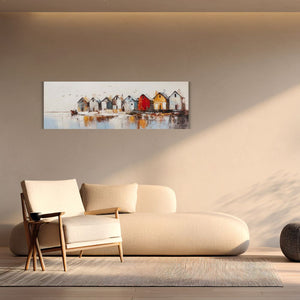 An einer Wand hängt eine Acrylgemälde. Es ziegt kleine bunte Häuser am See oder Fjord., typisch Norwegen. Die Einrichtung des Wohnzimmers ist dänisch.