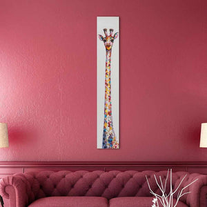 An einer roten Wand hängt eine bunte Giraffe die mit Acrylfarbe im Tupfentechnik gemalt wurde. 