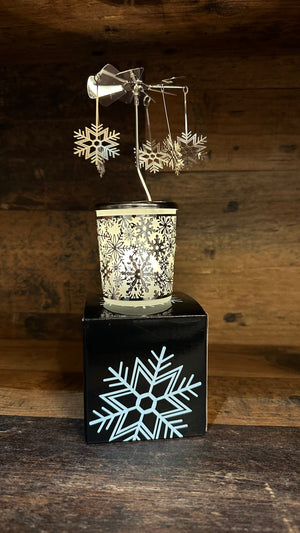 Windlicht mit einem Karusell und angehangenen Schneeflocken. Durch das satinierte Glas scheint das Teelicht welches das Oberteil durch die Wärme drehen lässt.