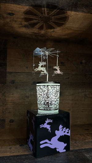 Glas Karusell Windlicht mit angehangenen Rentier steht auf einer schönen Geschenkbox