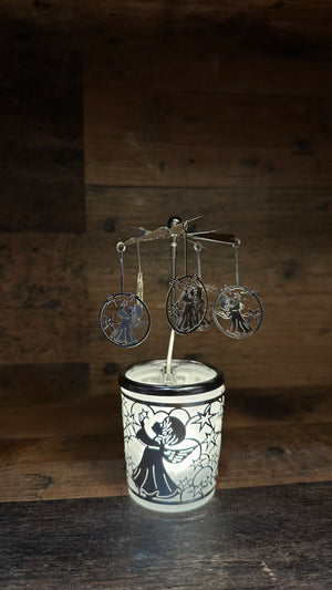 Dekoratives Windlicht mit einem Karusell an dem Engel mit kleinen Sternen hängen.