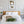 Skandinavisches Schlafzimmer-Design mit dem gerahmten XXL Frauenporträt-Gemälde „Gold covered Beauty“  über dem Holzbett. Das moderne Schwarz-Weiß-Wandbild mit glänzenden Goldakzenten hängt an einer hellgrauen Wand, perfekt abgestimmt auf weiße Kissen, hängende Nachttischlampen und grüne Zimmerpflanzen.
