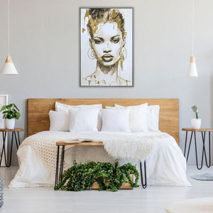 Skandinavisches Schlafzimmer-Design mit dem gerahmten XXL Frauenporträt-Gemälde „Gold covered Beauty“  über dem Holzbett. Das moderne Schwarz-Weiß-Wandbild mit glänzenden Goldakzenten hängt an einer hellgrauen Wand, perfekt abgestimmt auf weiße Kissen, hängende Nachttischlampen und grüne Zimmerpflanzen.