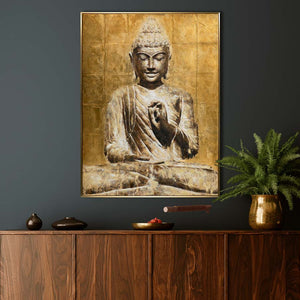An der dunklen Wand hängt ein wunderschönes Bold von einem goldfarbenen Buddha. Das Bild wirkt sehr harmonisch und strahlt ein große Ruhe aus.