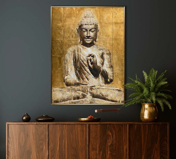 An der dunklen Wand hängt ein wunderschönes Bold von einem goldfarbenen Buddha. Das Bild wirkt sehr harmonisch und strahlt ein große Ruhe aus.