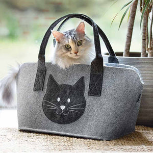 Aus einer Filztasche schaut eine süße Katze. Auf der Tasche ist ein niedlicher Katzenkopf