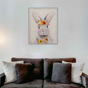 An der Wand hängt ein gemälde von einem Hasen mit Blumen. Der kleine Hase auch Häschen schaut sehr niedlich aus.