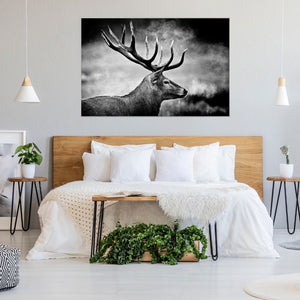 Stimmungsvolles schwarz-weißes Wandbild .Detailaufnahme eines Hirsches mit prächtigem Geweih, umgeben von atmosphärischem Nebel. Perfekt als dekoratives Bild über dem Doppelbett in einem gemütlichen, skandinavisch eingerichteten Schlafzimmer mit Holz-Akzenten.