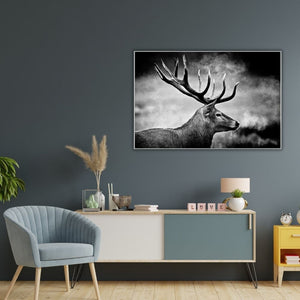 Die detailreiche Hirsch-Fotografie im Querformat harmoniert perfekt über einer weiß-blauen Kommode mit einem hellblauen Sessel und skandinavischer Dekoration vor einer anthrazitfarbenen Wand.