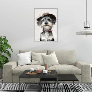 An einer weißen Wand hängt ein Gemälde von einem Schnauzer. Er trägt einen Hut und ein rotes Halsband.