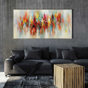 An einer dunkelgrauen Wand hängt das farbenfrohe Actylgemälde irisierende Spiegelung mit Rahmen.