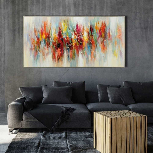 An einer dunkelgrauen Wand hängt das farbenfrohe Actylgemälde irisierende Spiegelung mit Rahmen.