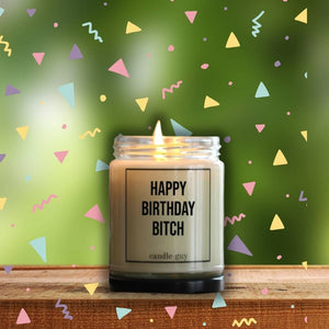Eine Duftkerze zum Geburtstag steht auf dem Tisch. Sie trägt die Aufschrift happy Birthday Bitch und ist für die beste Freundin.