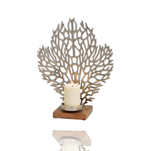 Kerzenständer mit einer Koralle aus Metall im Hintergrund. Der Standfuß besteht aus Mangoholz. Wenn die Kerze leuchtet gibt es eine interessante Lichtbrechung.
