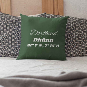 Dorfkind Dhünn und die Kooerdinaten stehen auf einem grünen bestickten Kissen welches zur Zierde auf einem Bett in Wermelskirchen, Bergisches Land steht.