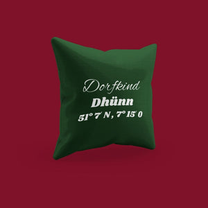 Auf dem grünen bestickte Kissen steht Dorfkind Dhünn und die Koordinaten. Das Kissen stammt aus der BRIDEMAKER Kissenkollektion.