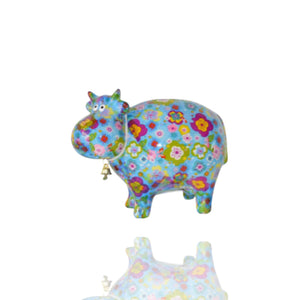 Die hellblaue Sparduse Kuh bella von Pomme Pidou trägt viele Blumen auf ihrem Körper. Sie sieht fast aus wie ein Retroobjekt aus den 70gern.