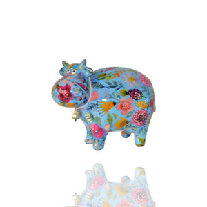 Die blaue Kuh mit den bunten Blumen ist eine Spardose der Marke Pomme Pidou. Die Kuh trägt ein kleines Glöckchen um den Hals und sie schaut echt drollig in die Gegend.