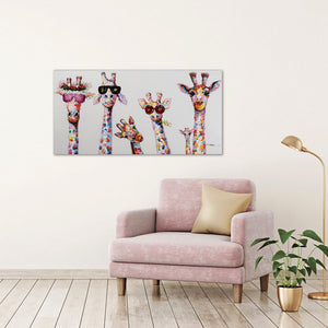 An der Wand hängt eine Gemälde auf dem bunte Griaffen mit Sonnenbrillen zu sehen sind. Die Giraffenfamilie schein eine Party zu feiern. Unter dem Gemälde steht ein rosa Sessel